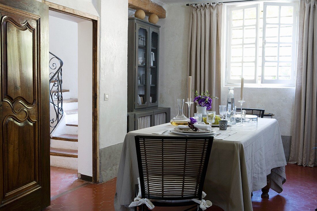 Gedeckter Tisch in provenzalischem Esszimmer mit weißem Kalkanstrich