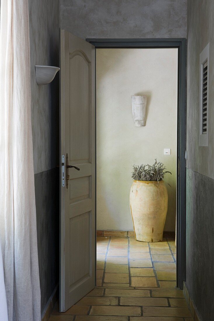 Open door leading into foyer with tiled floor and terracotta pot