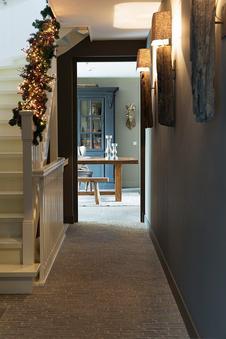 Hallway with festively decorated balustrade and view of dining area through open door