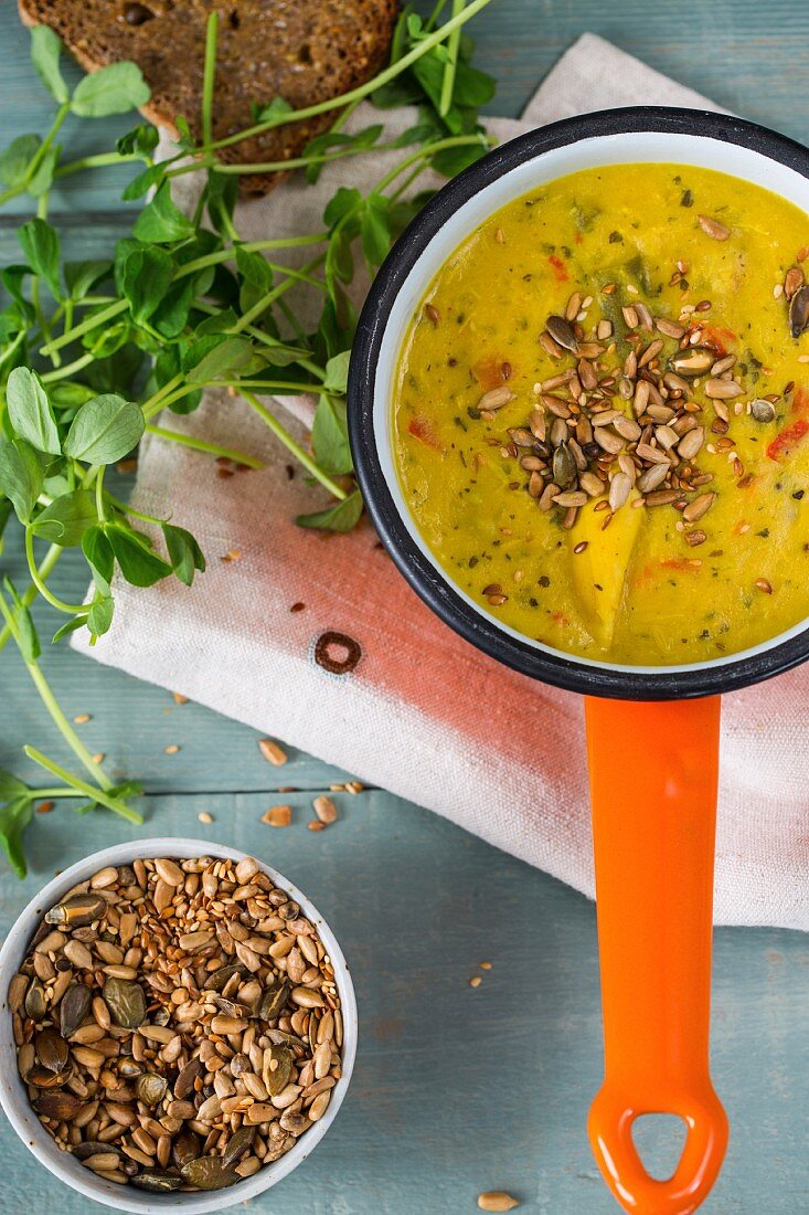 Würzige Kerala-Hühnersuppe mit gerösteten Kernen, Roggenbrot und Erbsensprossen