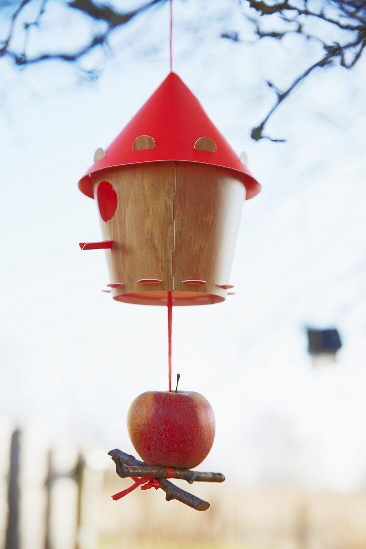 A bird house decorated with an apple