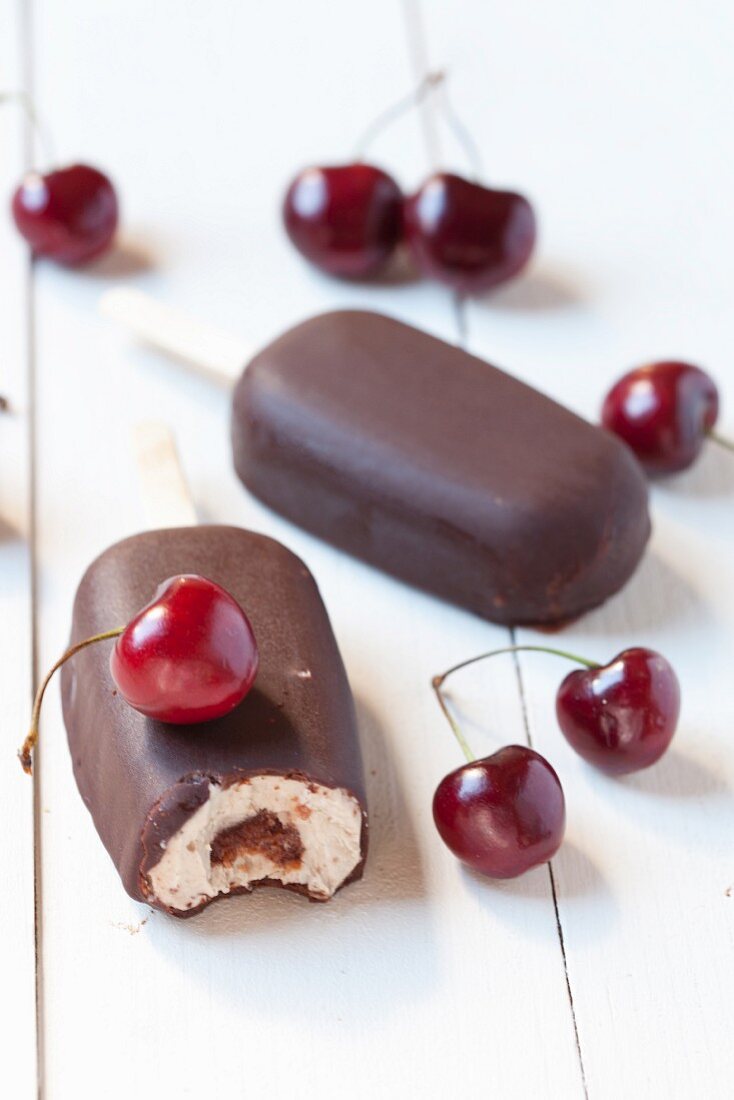 Chocolate-covered banana and cherry ice cream stick and fresh cherries