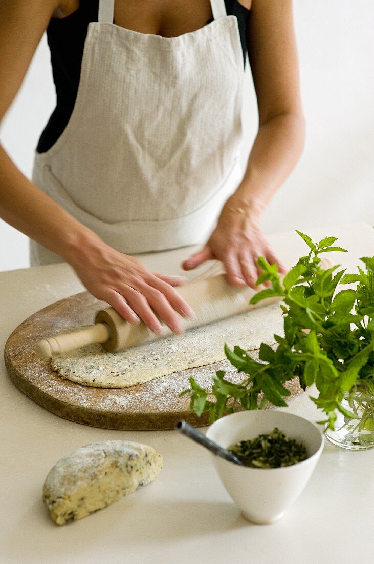 Bread dough being rolled out with a rolling pin