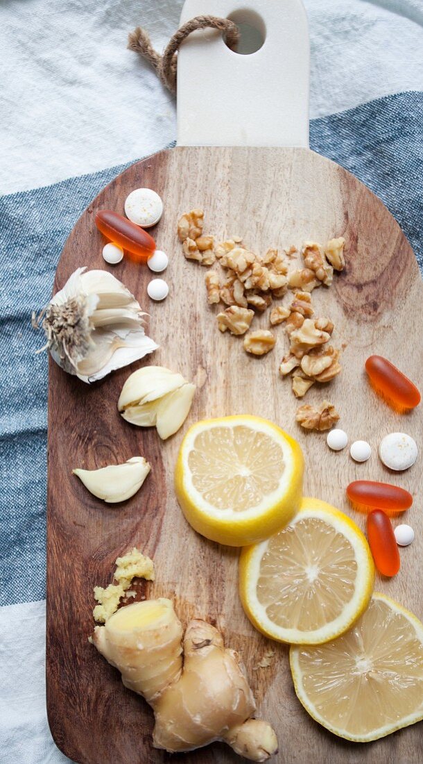 Lemon, ginger, garlic and tablets on a chopping board
