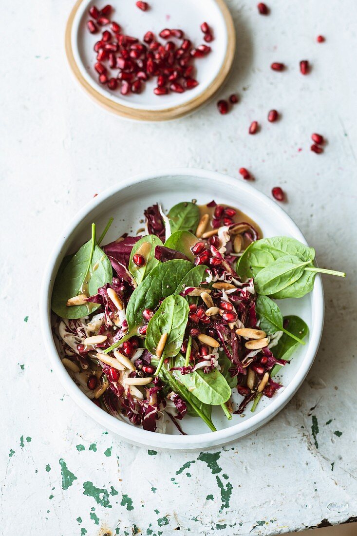 Spinach salad with pomegranate seeds, radicchio and pine nuts