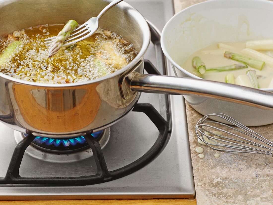 Chopped asparagus being deep fried