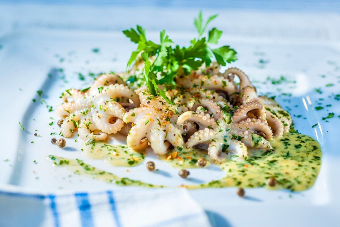 Kleine Oktopusse in Kräutersauce mit Kapern