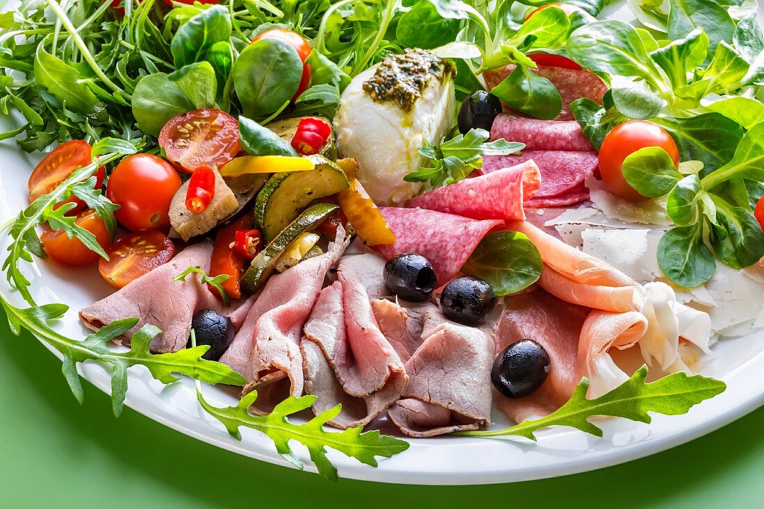 An anti-pasti platter with roast beef, cold cuts, cherry tomatoes and olives