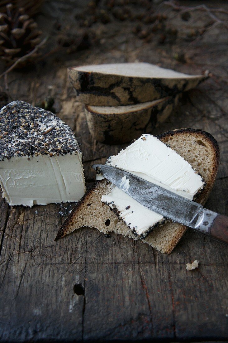 Cheese with a pepper crust and a slice of bread