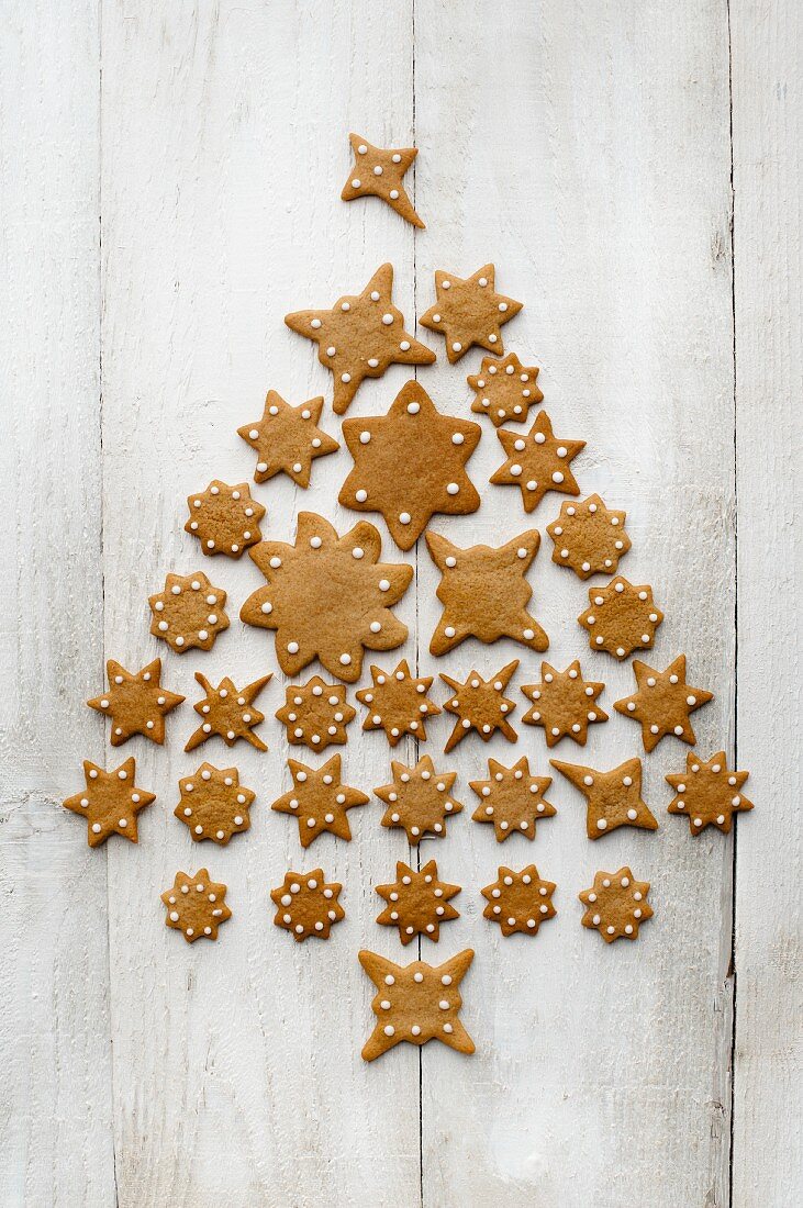 A Christmas tree made from star-shaped gingerbread on a light wooden surface