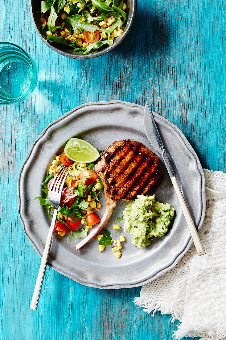 Gegrilltes Schweinekotelett mit Salat und Guacamole (Mexiko)