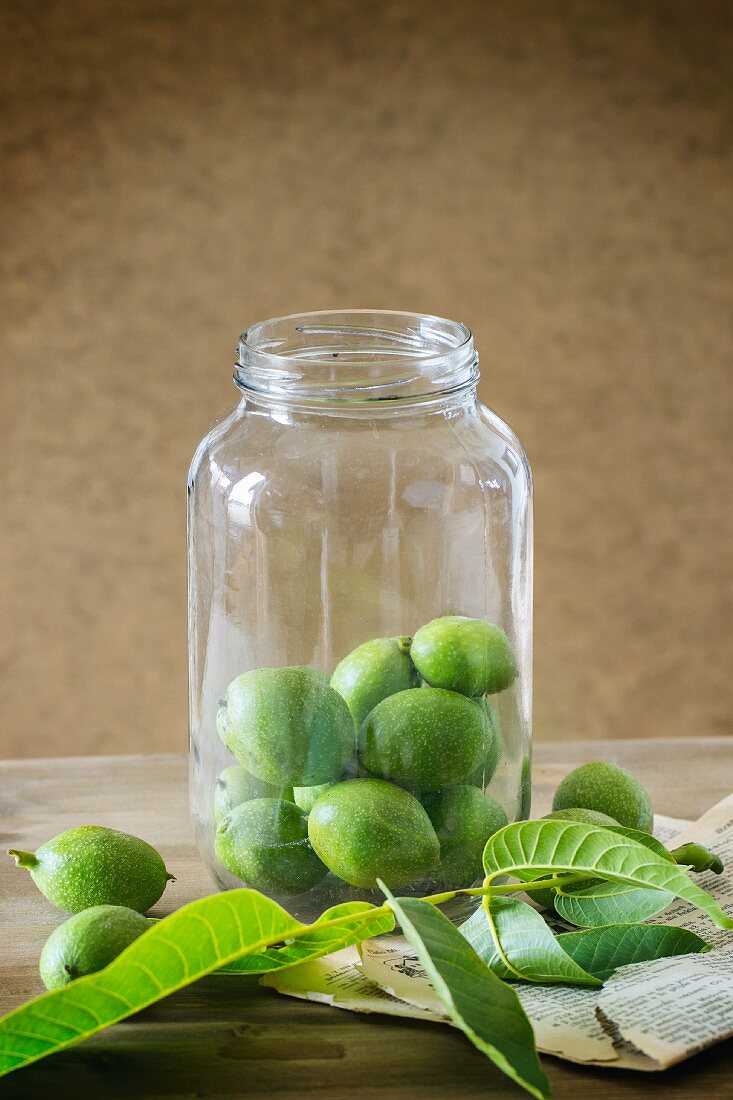 Young green walnuts in a glass jar for making jam