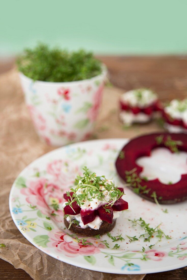 Pumpernickel canapés with flower-shaped beetroot, cream cheese and cress