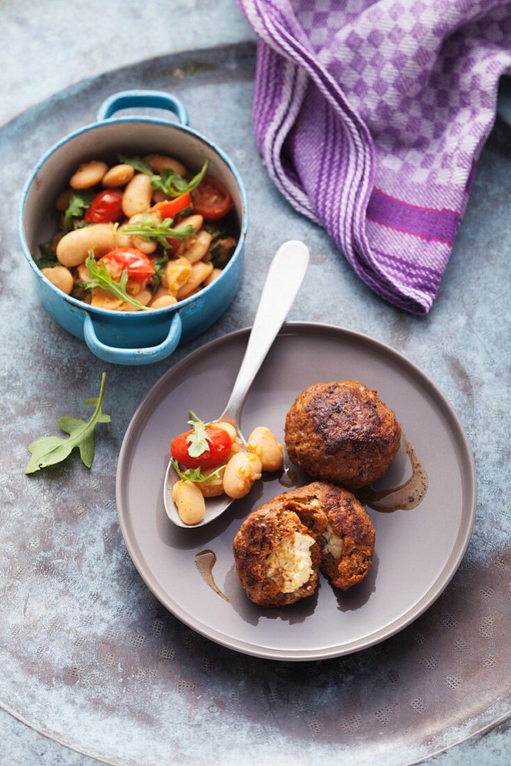 Meatball filled with feta cheese and served with a white bean medley