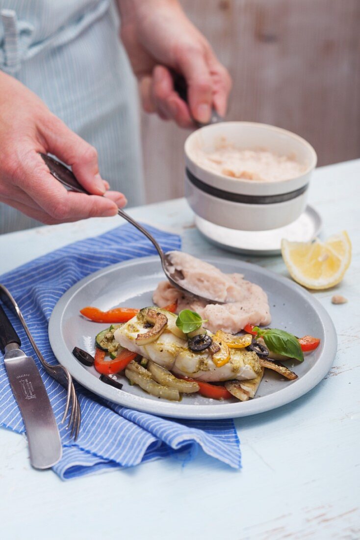 Gedämpftes Fischfilet aus der Alufolie mit weißem Bohnenpüree anrichten