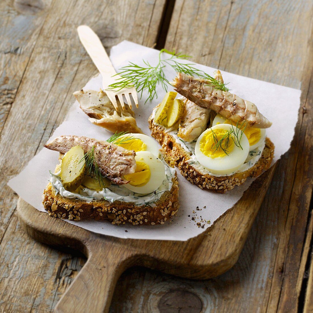 Slices of bread topped with mackerel, hard-boiled eggs and gherkins