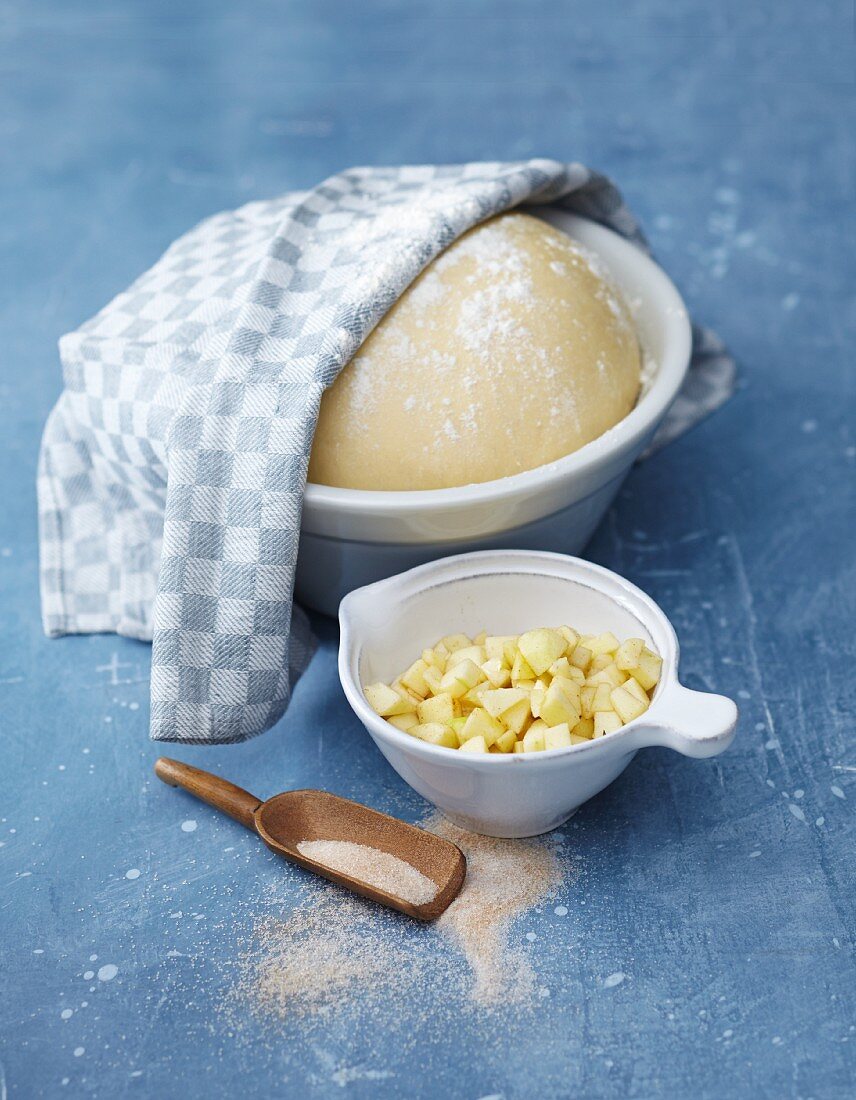 Yeast dough and a bowl of diced apple