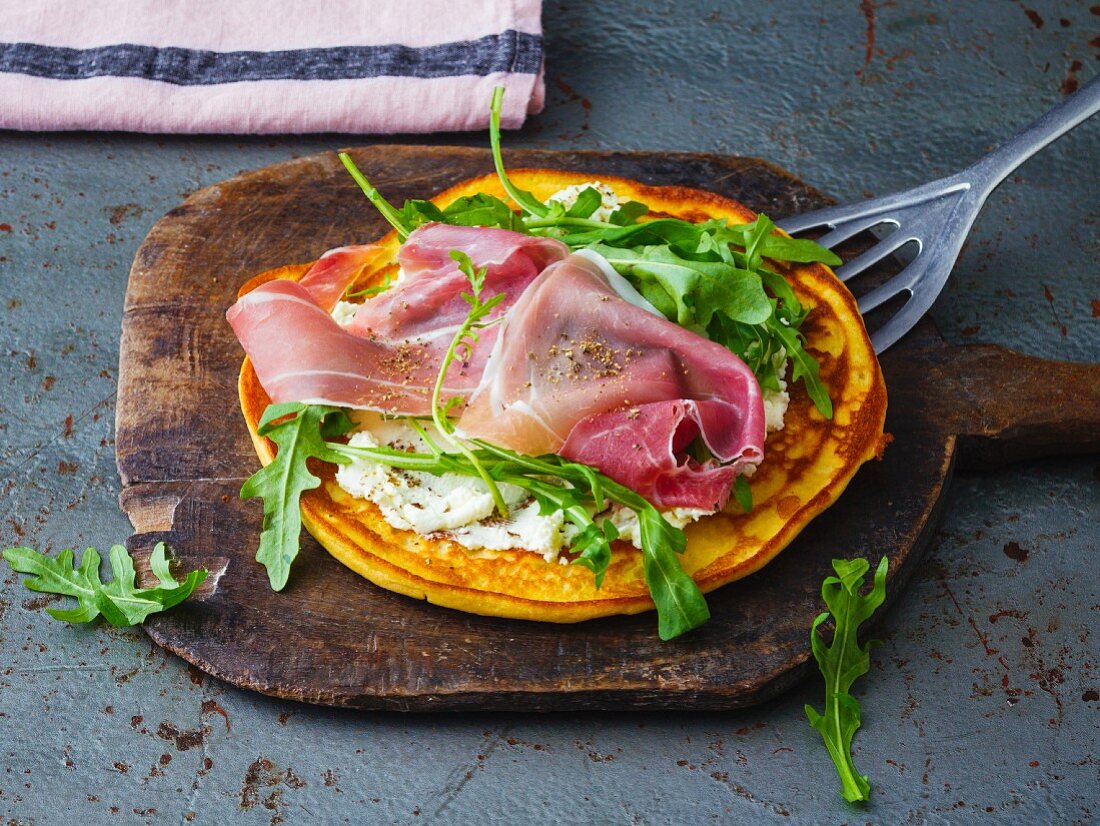 A savoury soya pancake with cream cheese, rocket and Parma ham