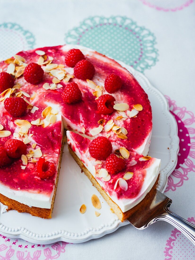 Cream cheese cake with raspberry sauce and flaked almonds