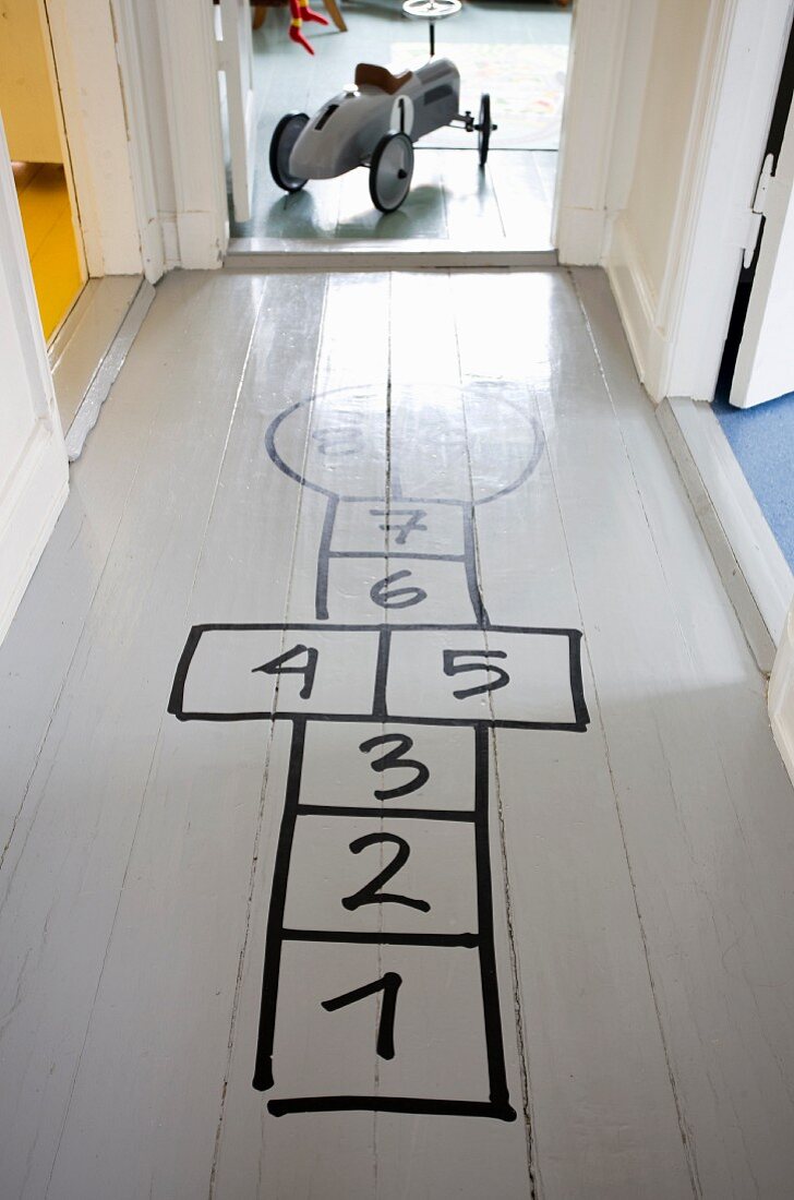 Hopscotch grid drawn on grey hallway floor