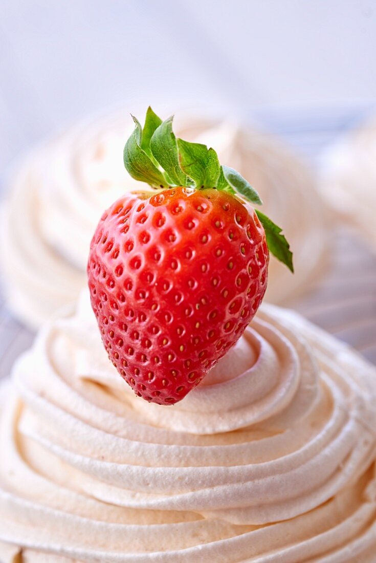 A meringue decorated with a strawberry (close-up)