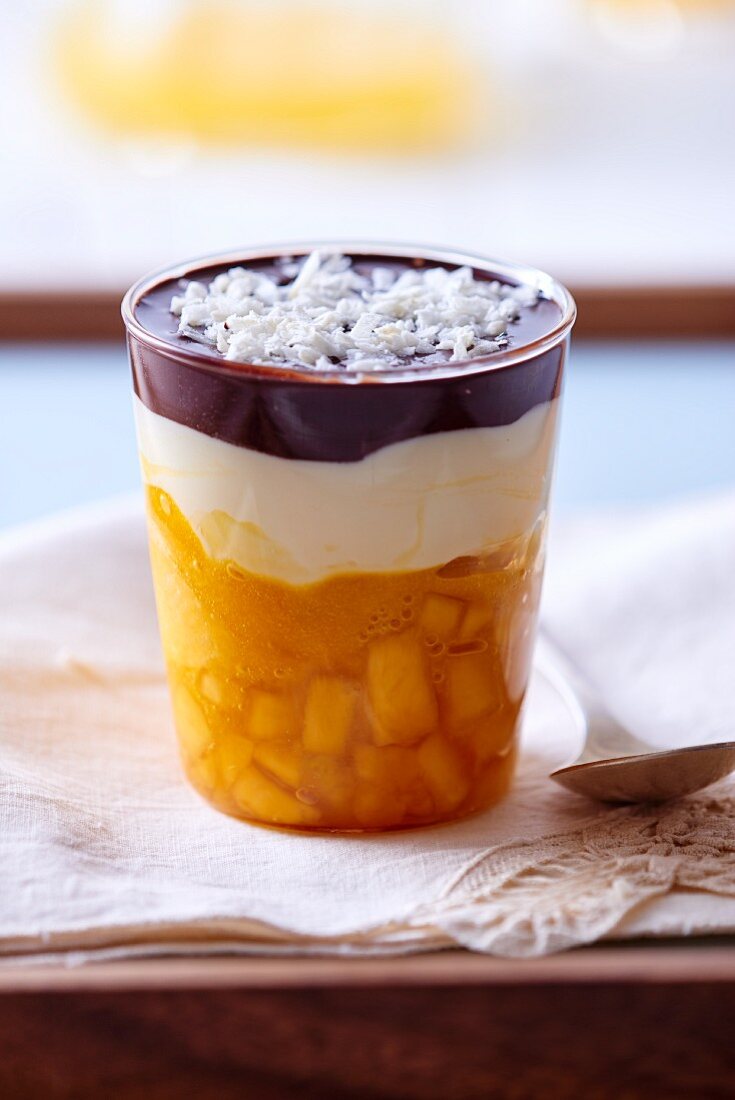 Schichtdessert mit Mangosorbet, Sahne, Schokolade & Kokosraspeln