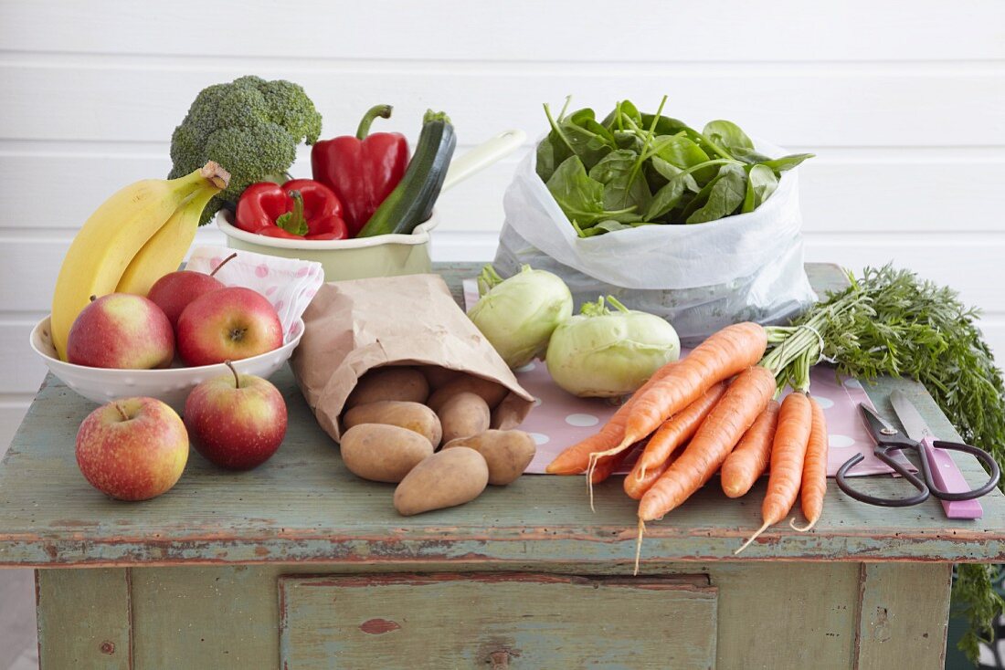 An arrangement of vegetables and fruit on a vintage kitchen cupboard