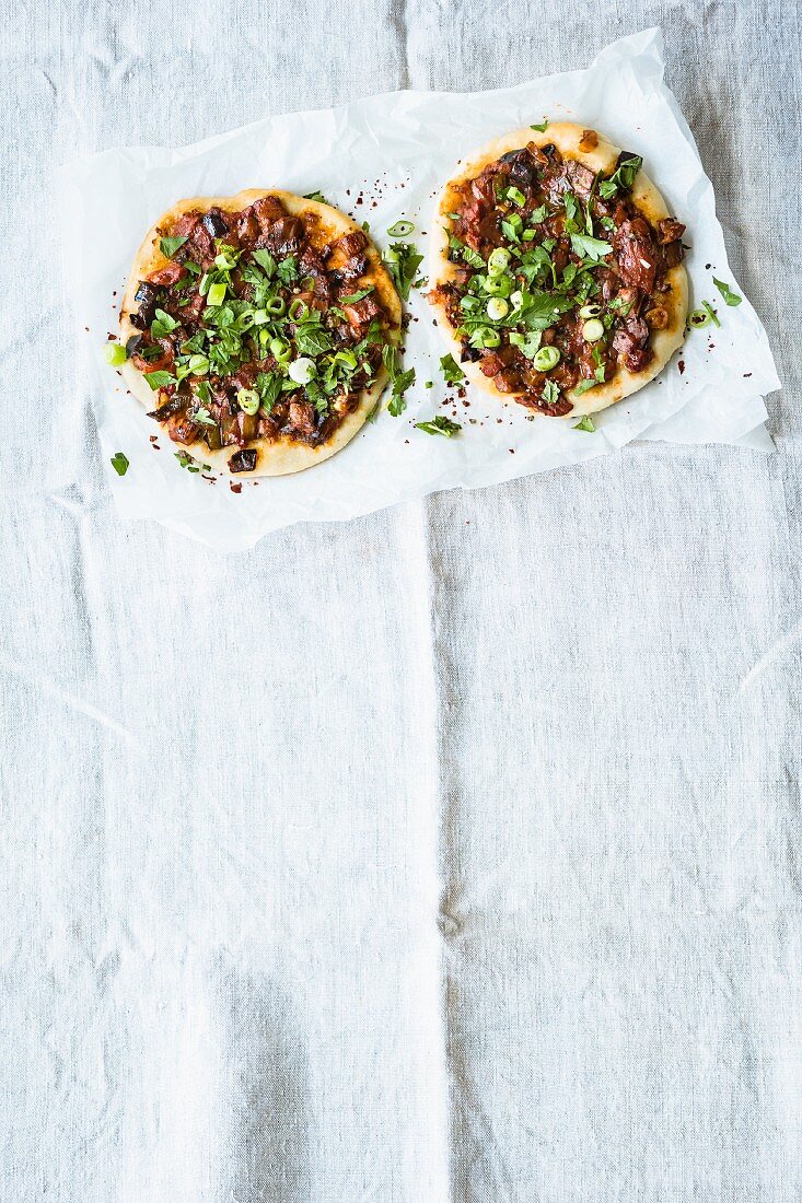 Mini Turkish pizzas topped with aubergines, mint and spring onions