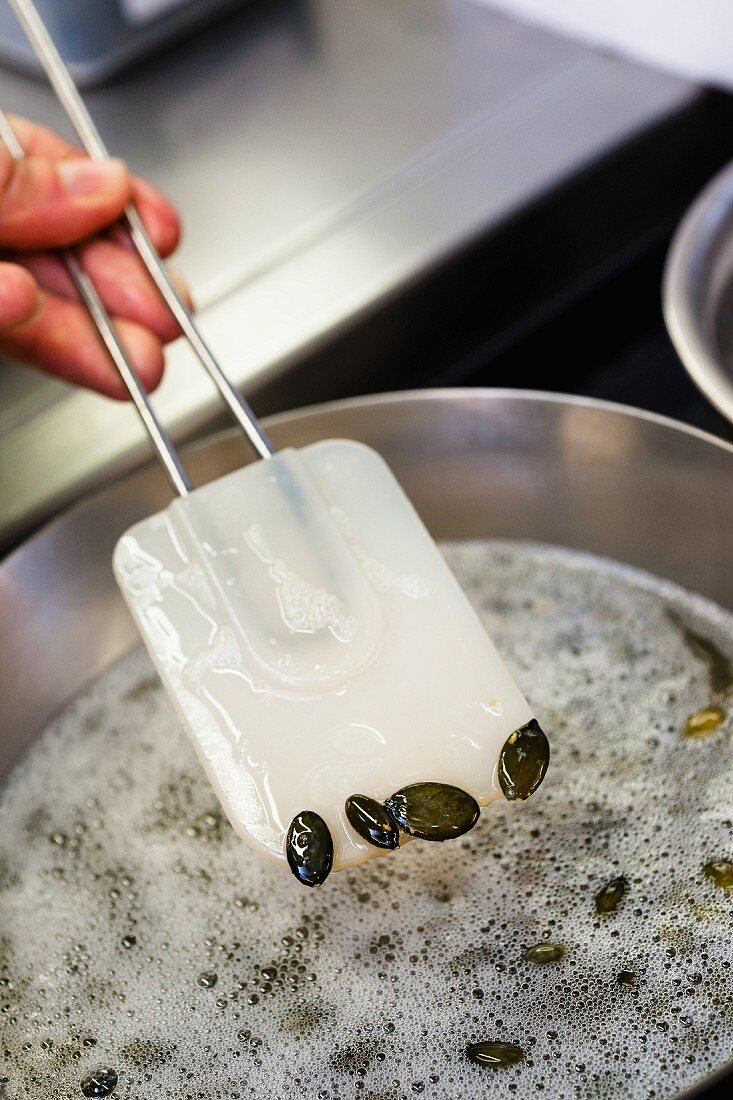 Pumpkin seeds being heated in oil, restaurant 'La Vie', Osnabrück