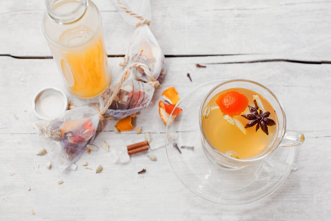 Ingwer-Orangen-Zitronen-Sirup in Flasche und als Tee mit Gewürzen