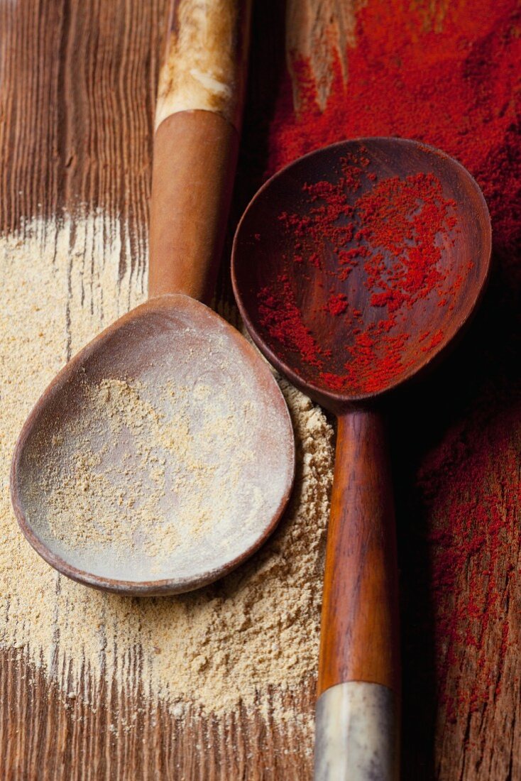 Curry powder and paprika powder on wooden spoons