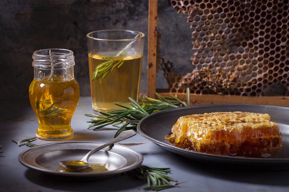 Honey in a jar with rosemary, and honeycomb on a vintage plate