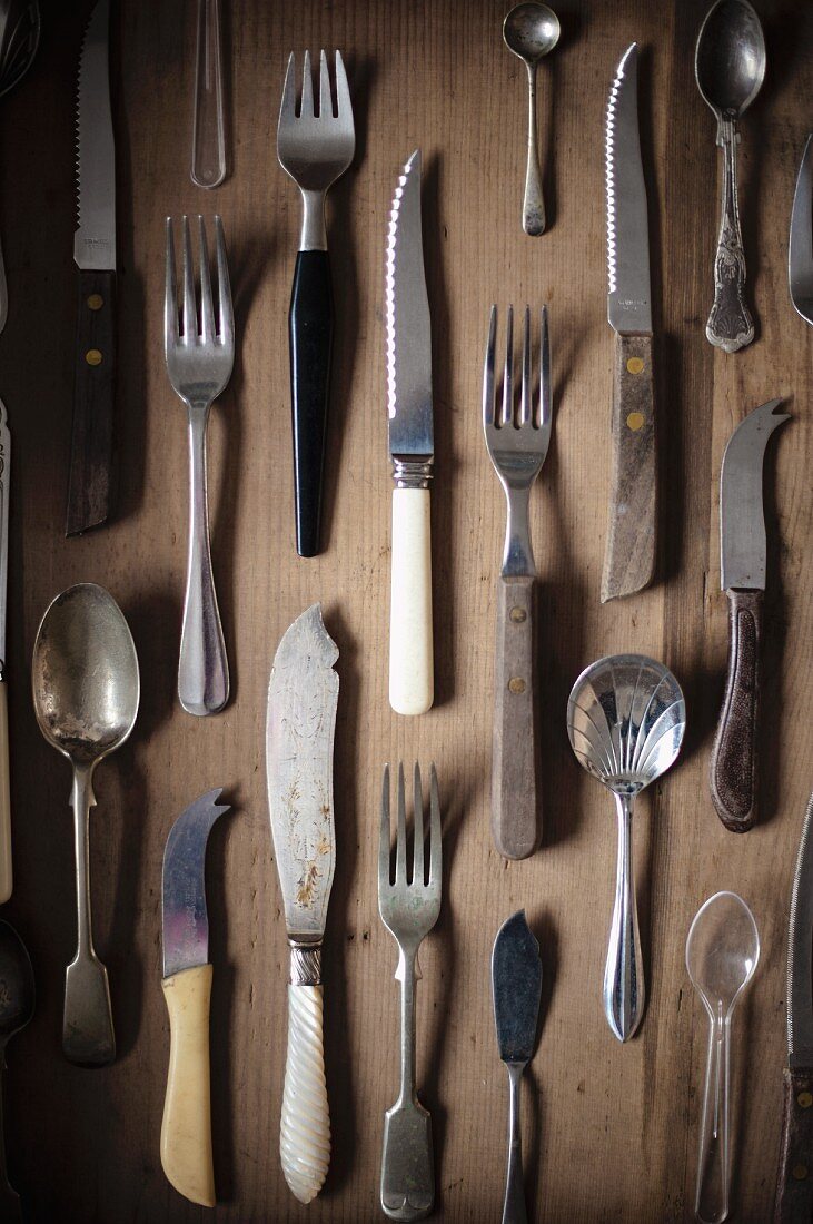 Various items of vintage cutlery on a wooden surface