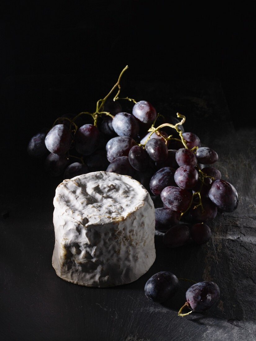 French soft cheese Petit Chaource with red grapes