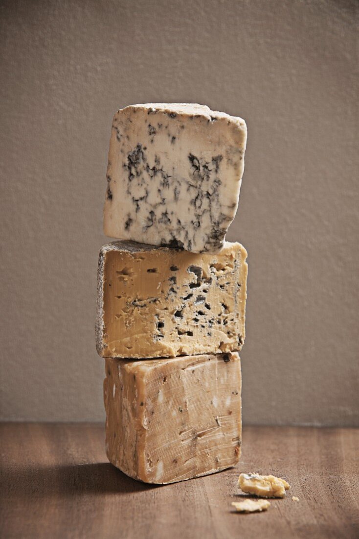 A stack of various cheeses, veined and unveined