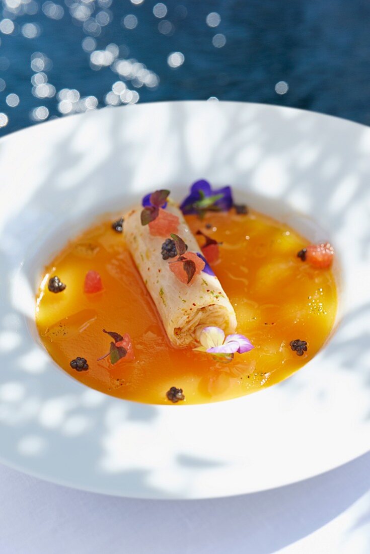 Cannelloni filled with crab in a sauce with edible flowers