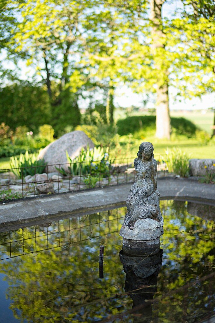 Stone statue in garden pond