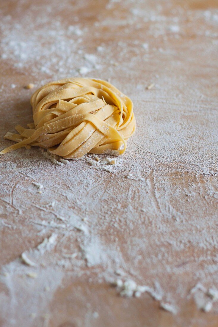 Fresh, uncooked pasta on a floured wooden board
