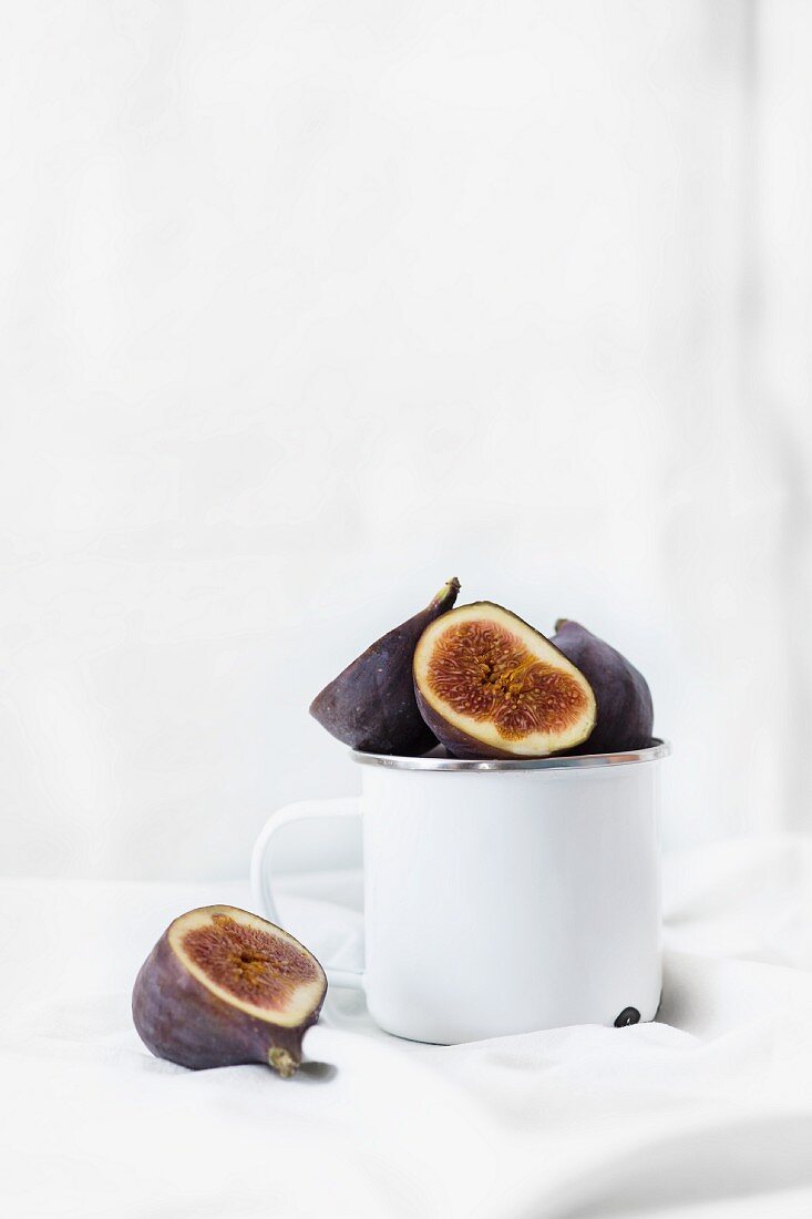 Halved fresh figs in a cup and next to it