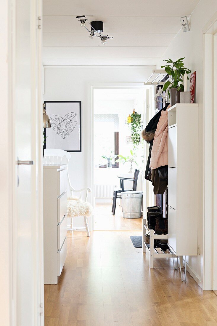 View into foyer with white cupboards and coat rack