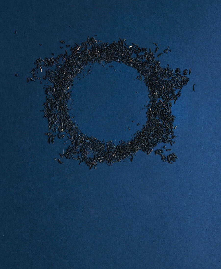 Ring aus Teeblättern auf dunkelblauem Untergrund