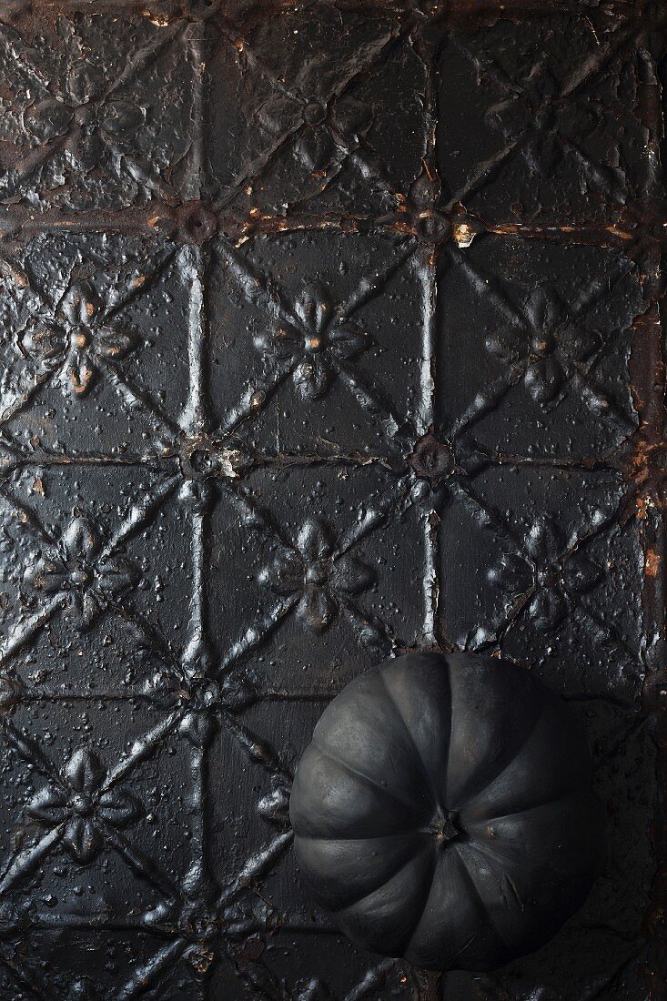 Black pumpkin on metal surface