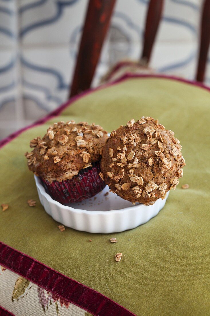 Carrot and lemon muffins with oats on an upholstered chair