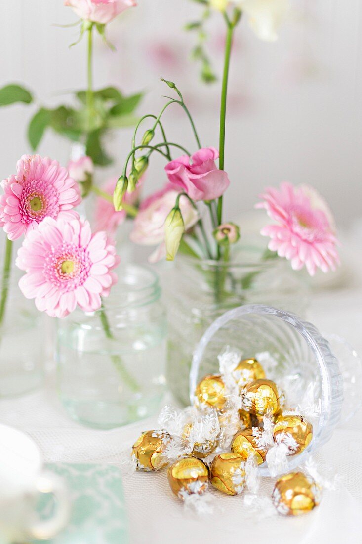 Goldene Bonbons und rosa Blumendeko am Buffet