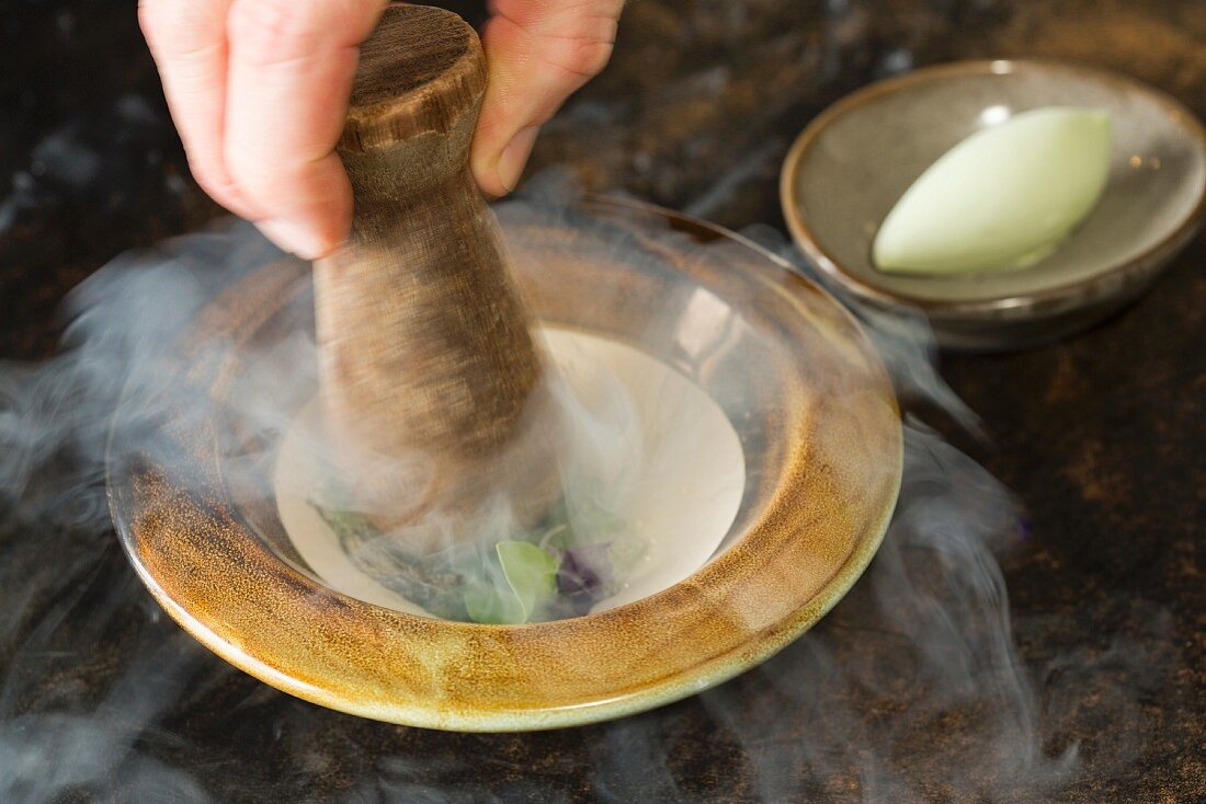 Frozen violets being crushed next to a celery, coconut and cabbage sorbet at the Vue de Monde Restaurant, Melbourne, Australia