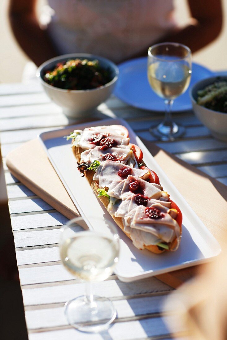 An open ham sandwich with cherry compote outside on a table