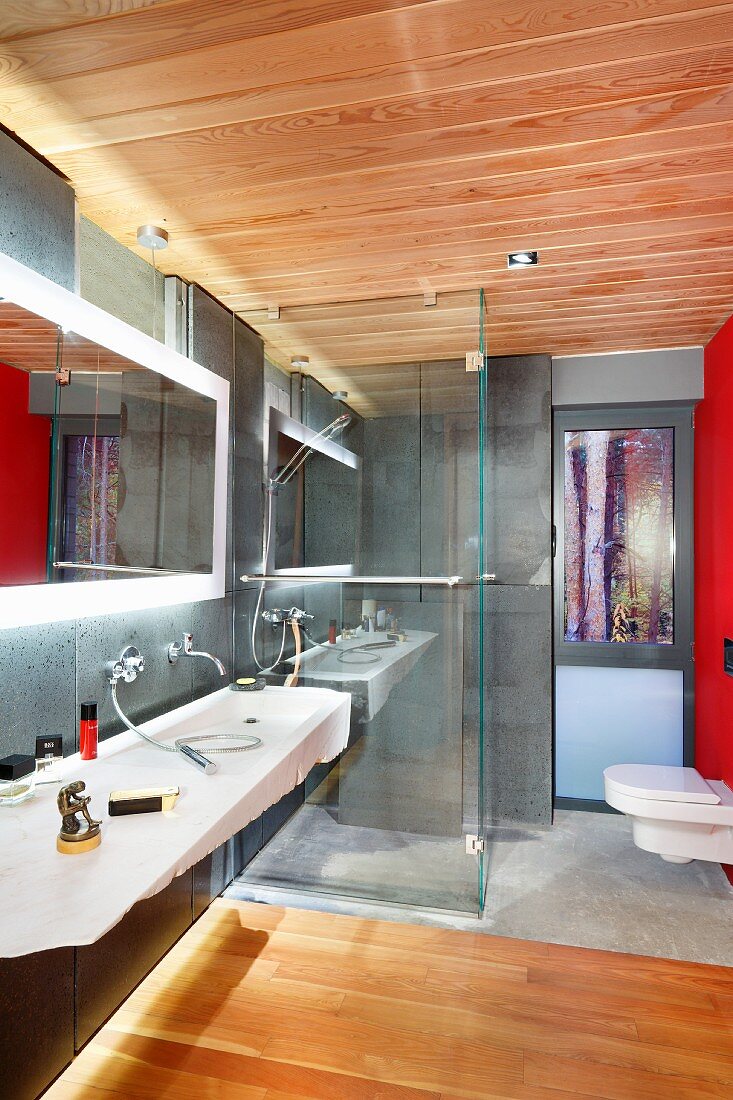 Modern bathroom with washstand, back-lit mirror, walk-in shower and toilet