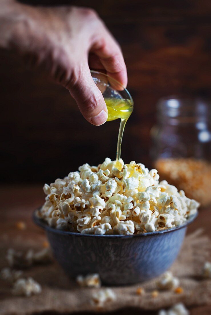 Geklärte Butter wird über Popcorn gegossen