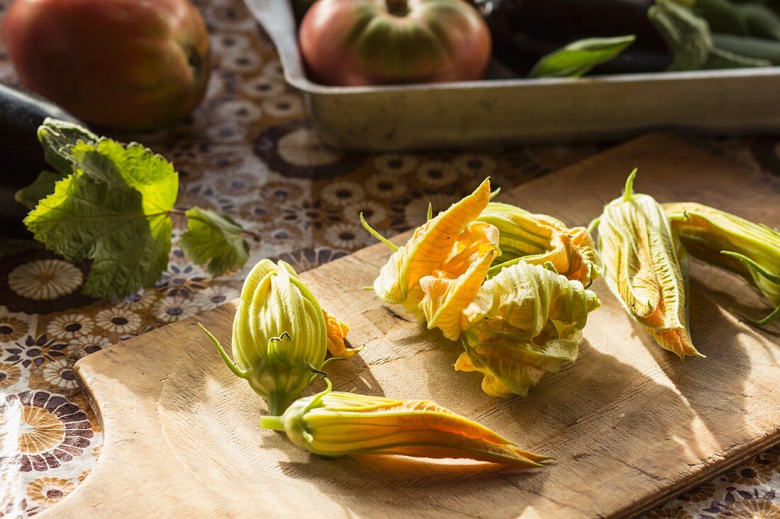 Courgette flowers on a wooden chopping board