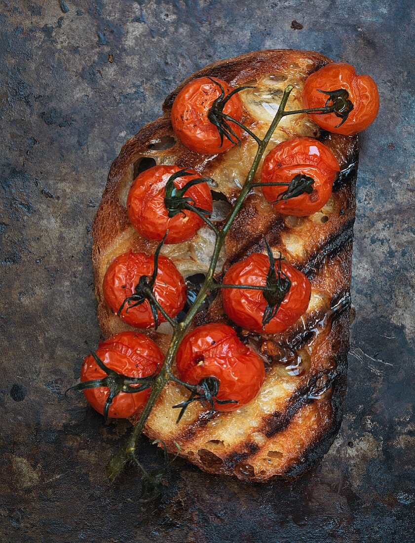 A slice of toasted bread topped with grilled tomatoes (seen from above)